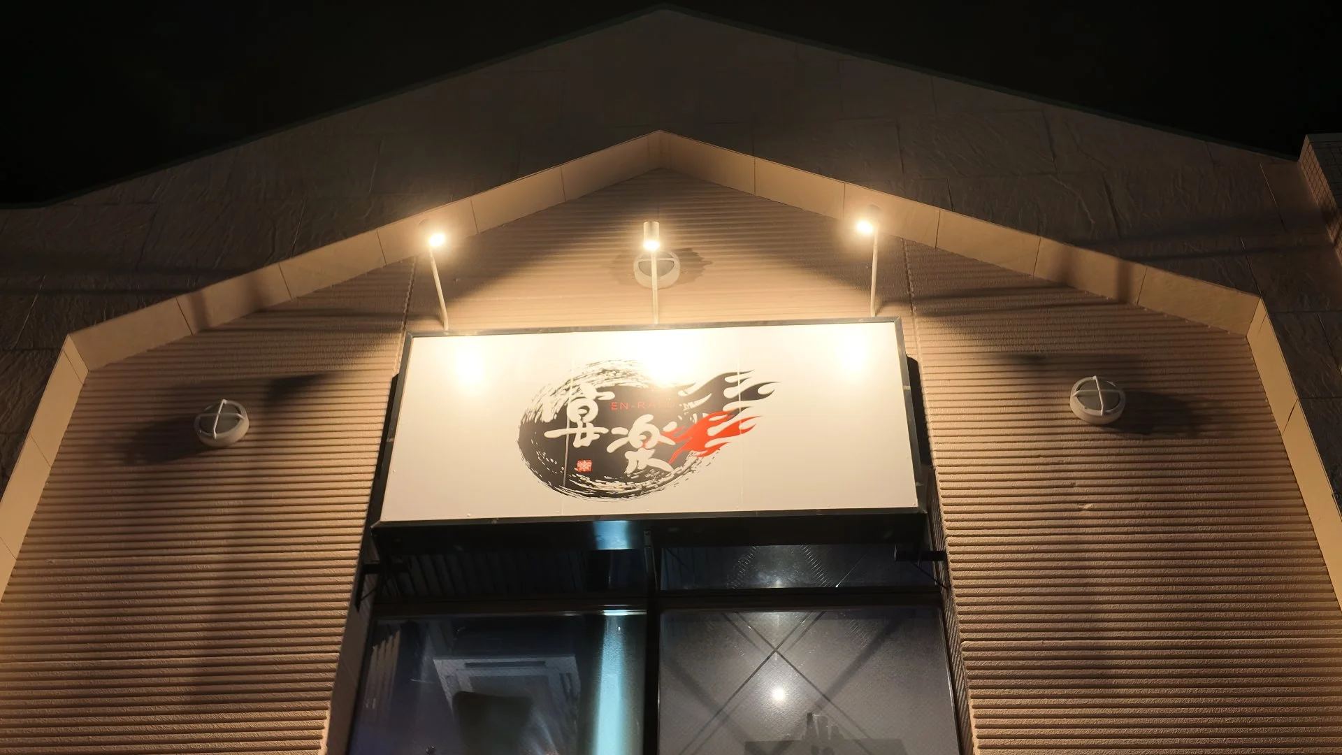 夜にライトアップされた居酒屋 宴楽の外観看板
