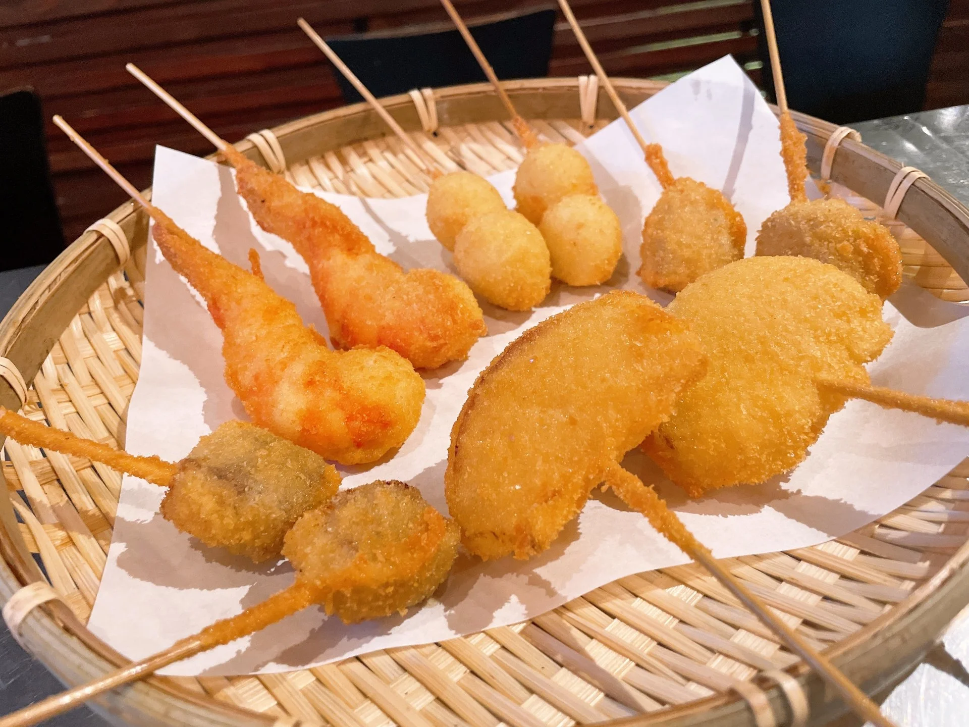 竹ざるに盛られた揚げたての串カツの盛り合わせ